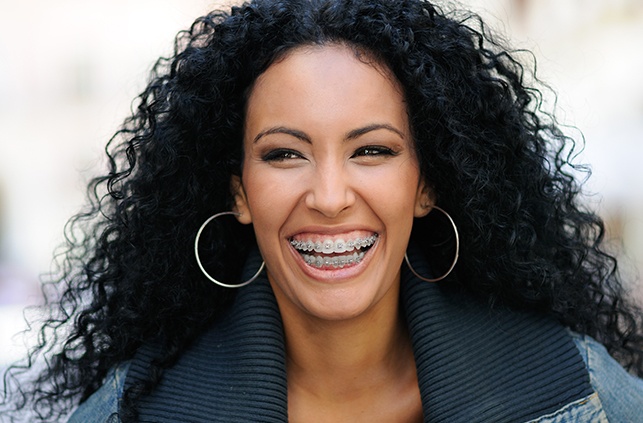 Woman with traditional braces smiling